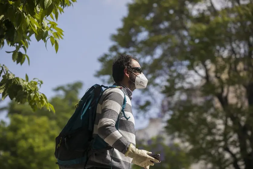 Un hombre camina con guantes y mascarillas.