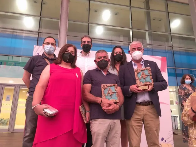 Mena con el premio junto al matrimonio acogedor tambi&eacute;n premiado.