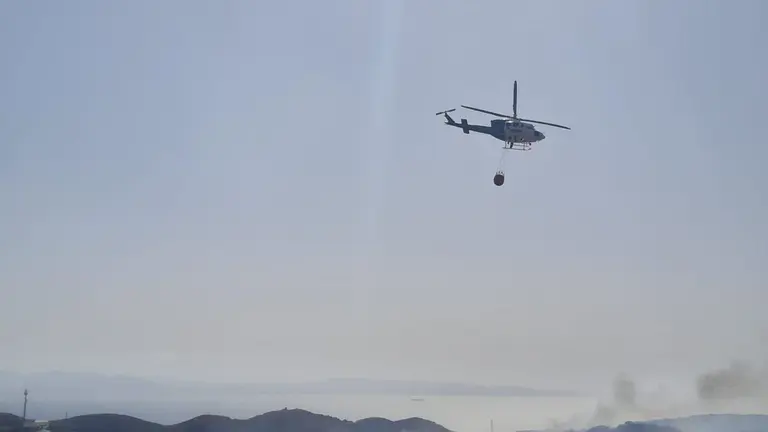 Un helic&oacute;ptero sobrevuela el fuego, ayer.