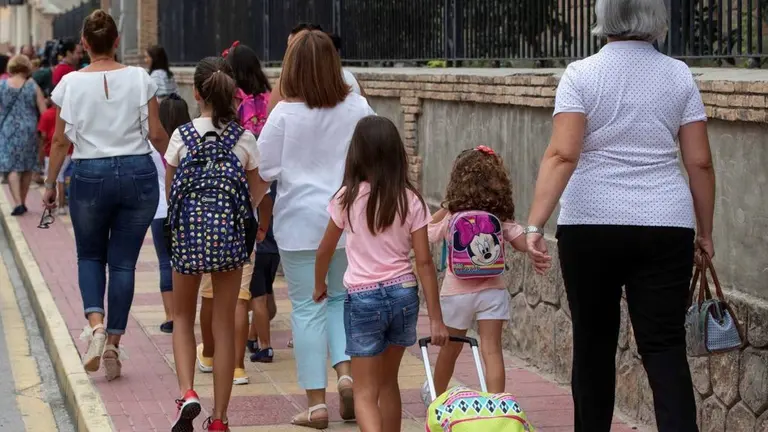 padres llevan a sus hijos al colegio