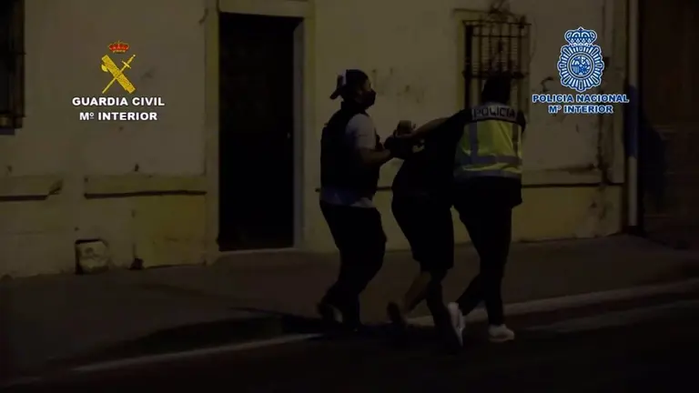 Agentes, con uno de los detenidos.